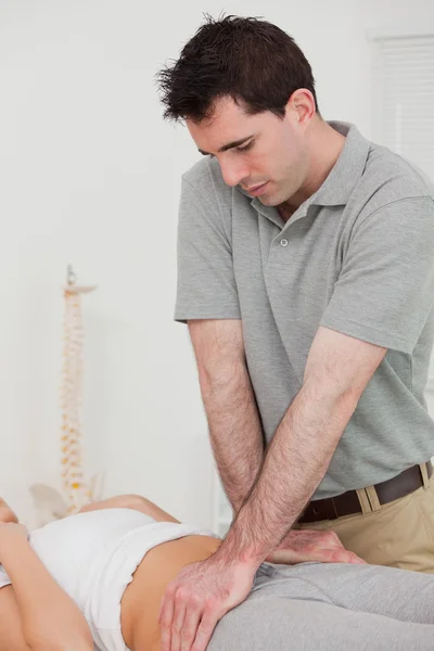 Fisioterapeuta serio manipulando la pelvis de un paciente — Foto de Stock