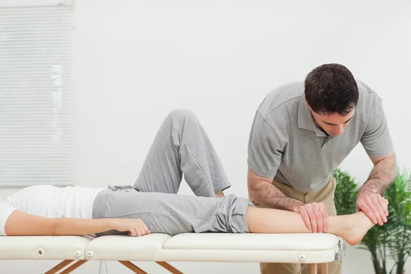 Chiropractor examining the foot of a woman — Stock Photo, Image