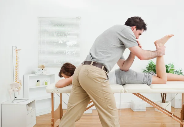 Brunette woman being stretched by a physiotherapist — Stock Photo, Image
