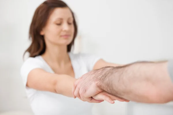 Practitioner extending the arms of a patient — Stock Photo, Image