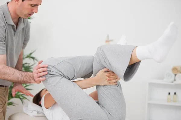 Mujer haciendo su ejercicio mientras es ayudada — Foto de Stock