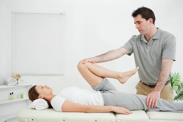 Vrouw liggend op haar rug terwijl uitgerekt — Stockfoto