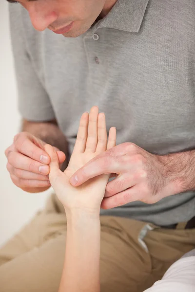 Hombre masajeando el pulgar de una mujer — Foto de Stock