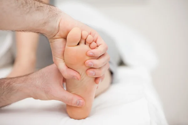 Two hands holding a foot — Stock Photo, Image