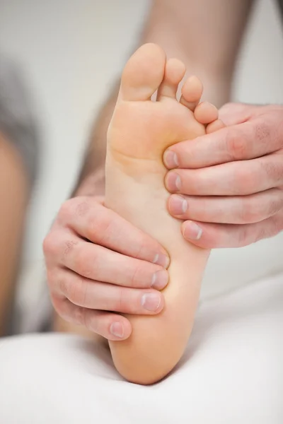 Fingertips touching the sole of a foot — Stock Photo, Image