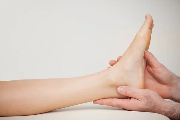 Chiropodist holding the foot of a patient — Stock Photo, Image