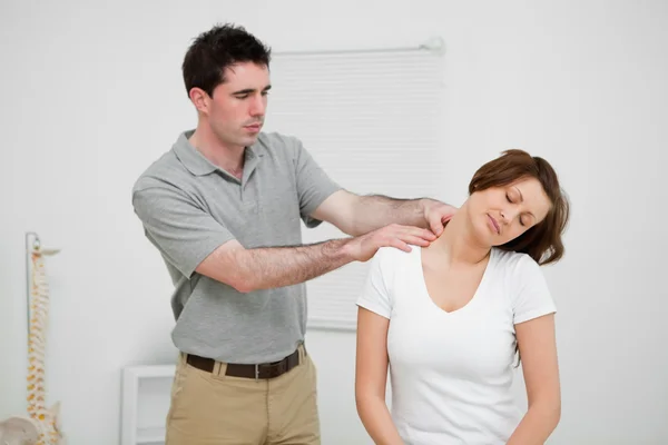 Praticante olhando para o pescoço de um paciente — Fotografia de Stock