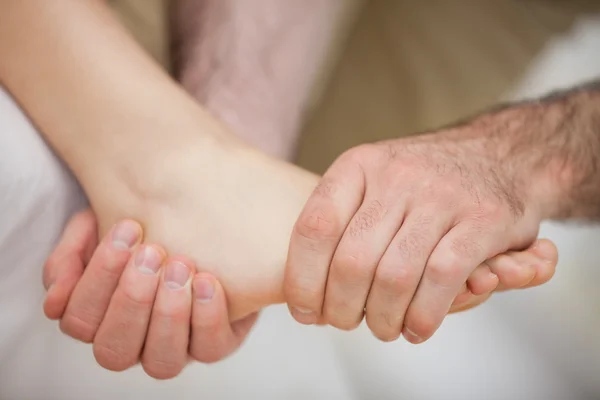 Fuß wird von einem Praktizierenden gehalten — Stockfoto