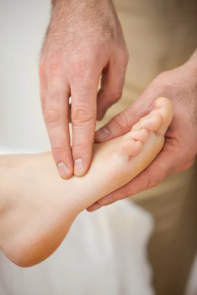 Two fingers palpating the muscles of a foot — Stock Photo, Image