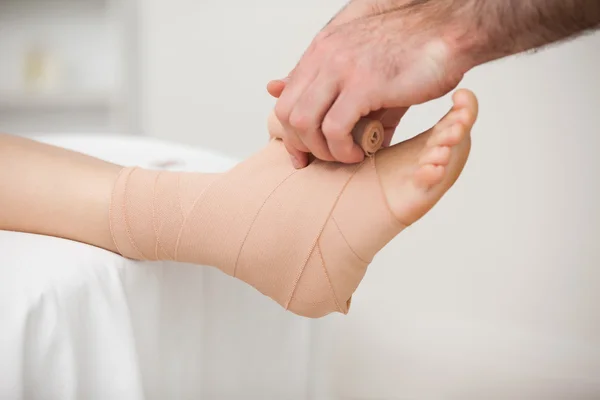 Practitioner bandaging an ankle — Stock Photo, Image