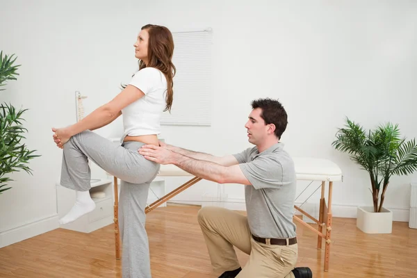 Mujer seria estirando su pierna — Foto de Stock