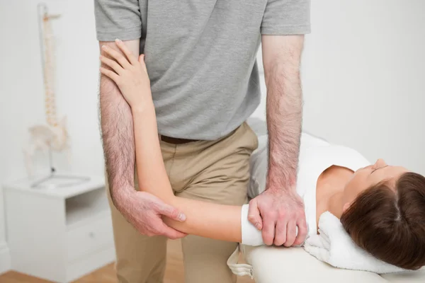 Fisioterapeuta pressionando o ombro de uma mulher — Fotografia de Stock