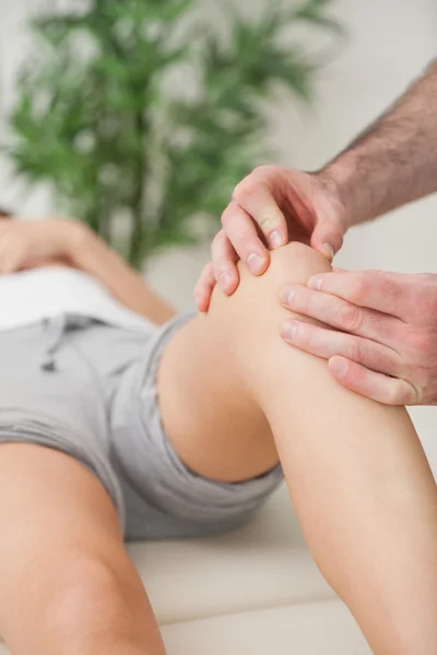 Dedos de um médico massageando uma perna — Fotografia de Stock