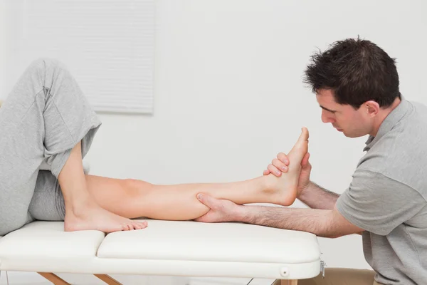 La pantorrilla de un paciente siendo masajeado por un fisioterapeuta — Foto de Stock