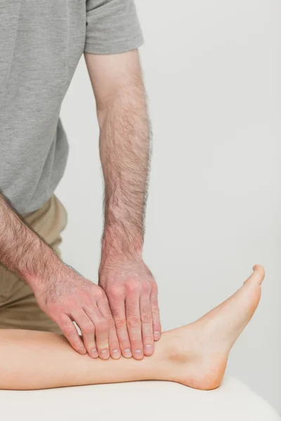 Fingertips massaging a shin bone — Stock Photo, Image