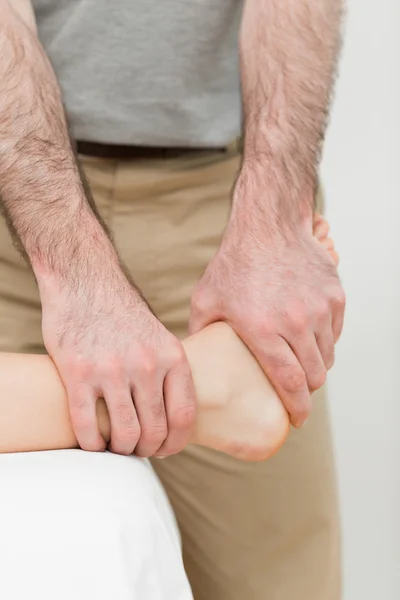 Osteopath manipulating the ankle of a patient — Stock Photo, Image