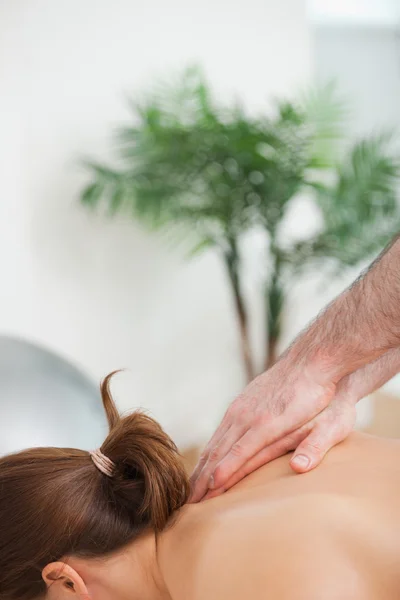 Практикующий делает массаж верхней части спины своего пациента — стоковое фото