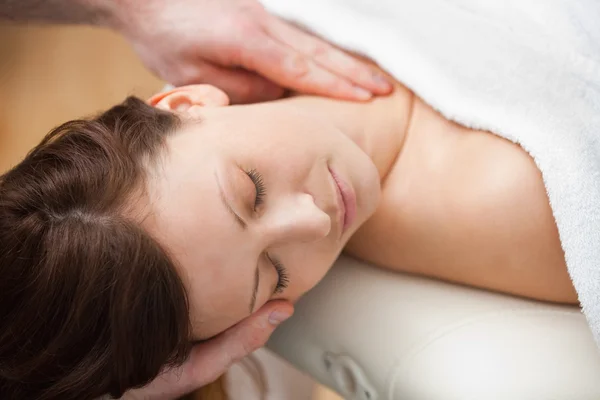 Doctor holding the head of a woman while massaging her neck — Stock Photo, Image