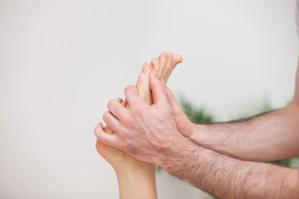 Doctor manipulating the foot of his patient — Stock Photo, Image