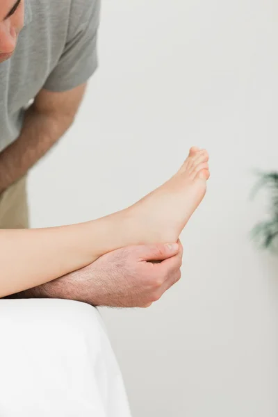 Podiatrist examining the foot of his patient — Stock Photo, Image