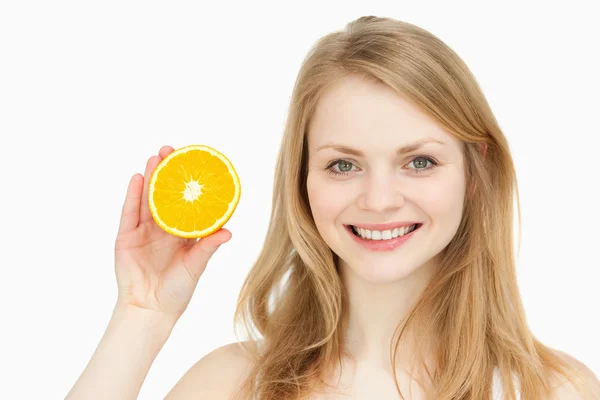 Mujer alegre presentando una naranja — Foto de Stock