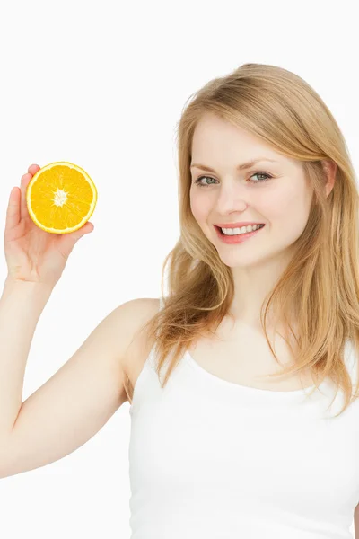 Mulher sorridente apresentando uma laranja — Fotografia de Stock