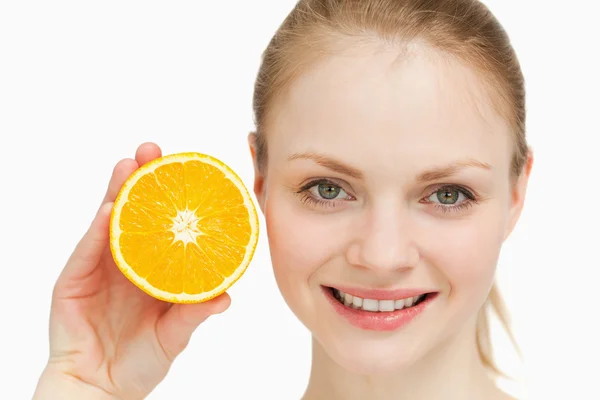 Κοντινό πλάνο του ένα χαμογελαστό γυναίκα παρουσιάζοντας ένα πορτοκάλι — Φωτογραφία Αρχείου