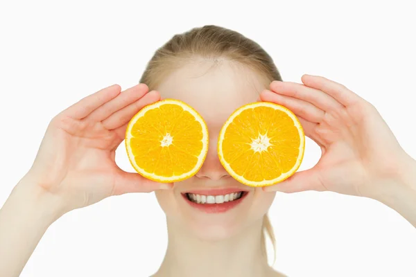Κοντινό πλάνο του ένα χαμογελαστό γυναίκα διάθεση πορτοκάλια για τα μάτια της — Φωτογραφία Αρχείου