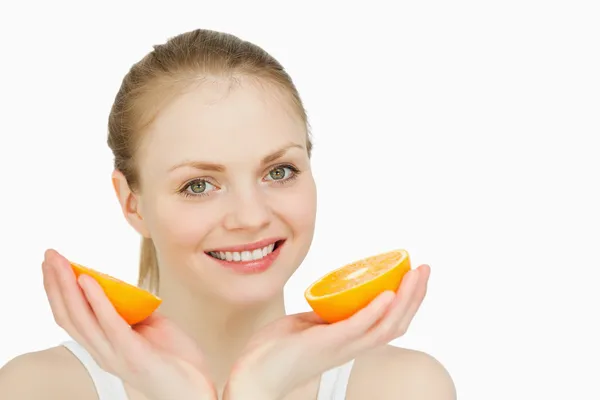 Mujer sonriente sosteniendo naranjas —  Fotos de Stock