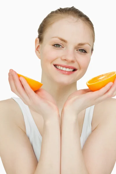 Κοντινό πλάνο του ένα χαμογελαστό γυναίκα, κρατώντας τα πορτοκάλια — Φωτογραφία Αρχείου