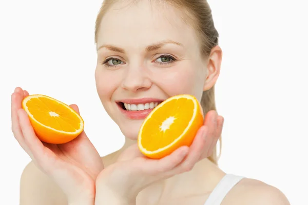 Close up of a cheerful woman holding oranges — Stock Photo, Image