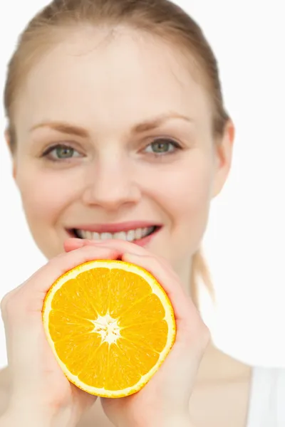 Close up of a woman squeezing an orange between her hands — Stock Photo, Image