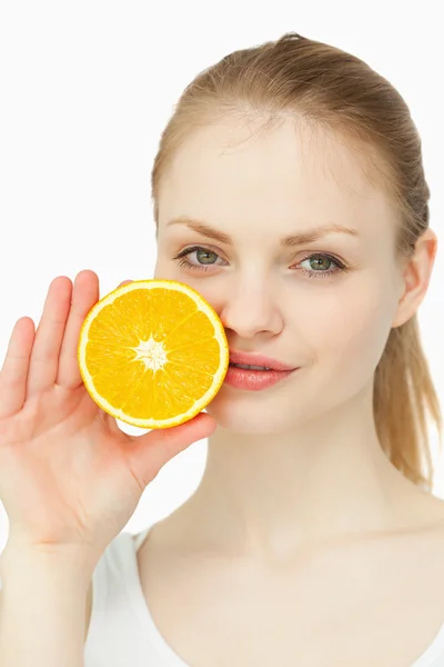Frau platziert eine Orange auf ihren Lippen — Stockfoto