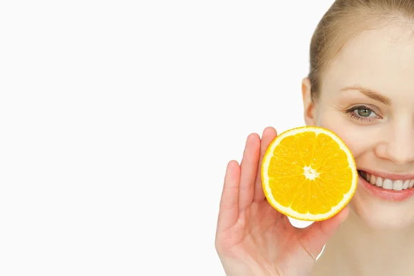 Close up de uma mulher segurando uma laranja na mão — Fotografia de Stock