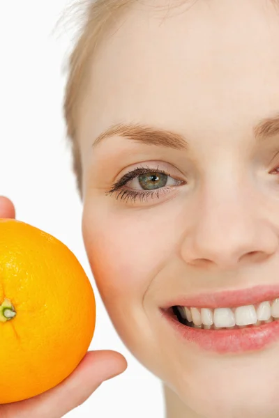 Primer plano de una mujer alegre sosteniendo una naranja — Foto de Stock
