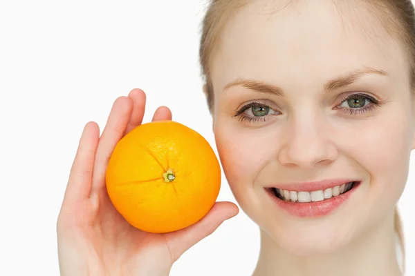 Mujer de pelo rubio sosteniendo una naranja — Foto de Stock