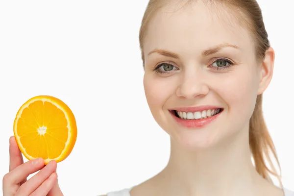 Lächelnde Frau präsentiert ein Orangenstück — Stockfoto