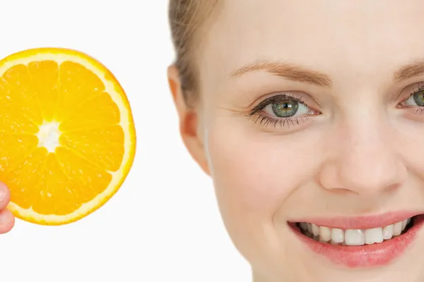 Close up of a woman presenting an orange slice — Stock Photo, Image