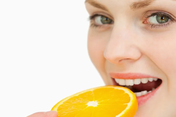 Κοντινό πλάνο μια γυναίκα διάθεση μια φέτα πορτοκάλι στο στόμα — Φωτογραφία Αρχείου