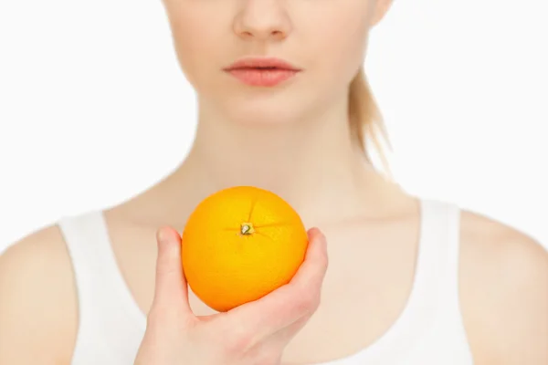 Mulher segurando uma laranja — Fotografia de Stock