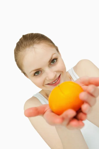 Mujer joven que presenta una mandarina — Foto de Stock