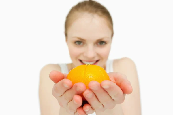 Mujer joven sosteniendo una mandarina — Foto de Stock