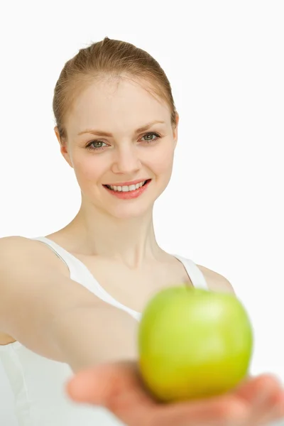Mulher jovem apresentando uma maçã — Fotografia de Stock