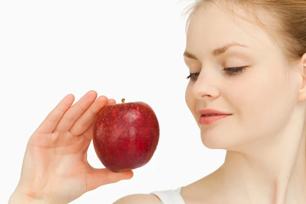 Kvinna med ett äpple medan du tittar på det — Stockfoto