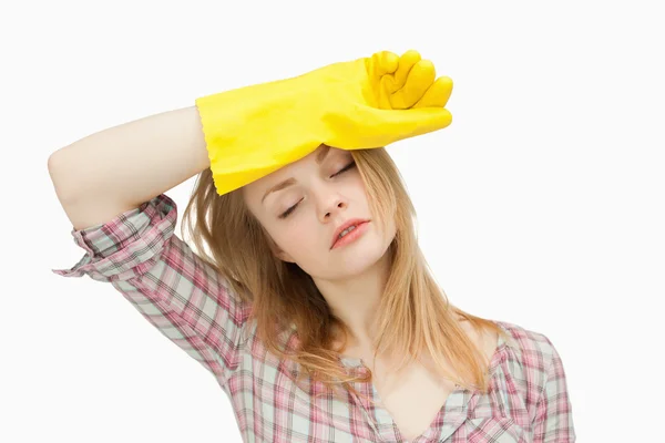 Woman wearing cleaning gloves while wiping her brow — Stock Photo, Image