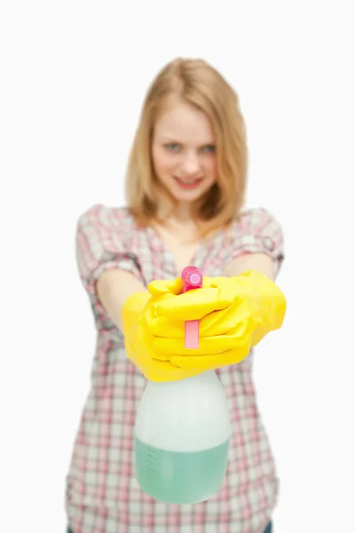 Mujer de pelo rubio sosteniendo una botella de spray — Foto de Stock