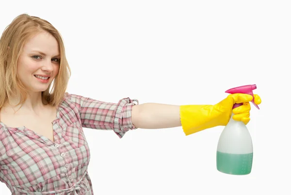 Smiling young woman holding a spray bottle — Stock Photo, Image