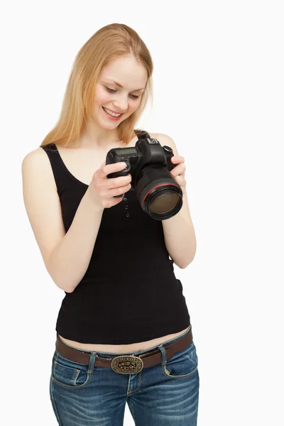 Γυναίκα που ψάχνει στην οθόνη της φωτογραφικής μηχανής, ενώ χαμογελώντας — Φωτογραφία Αρχείου