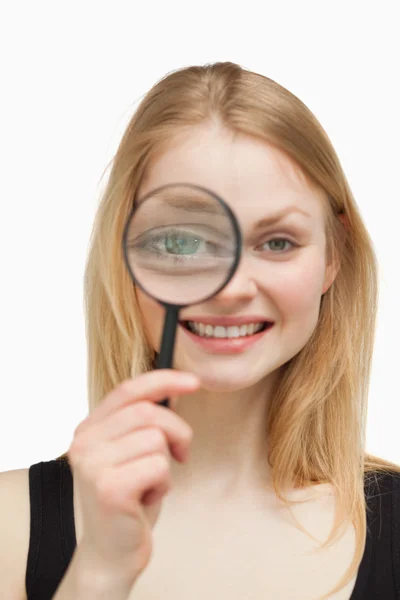 Joyful woman using a magnifying glass — Stock Photo, Image