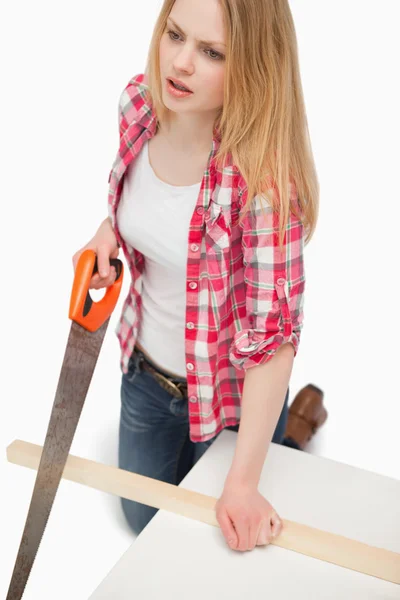 Woman using a wood saw — Stock Photo, Image